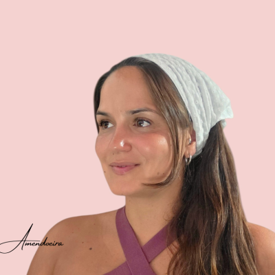 Mulher com lenço branco e top roxo com fundo rosa