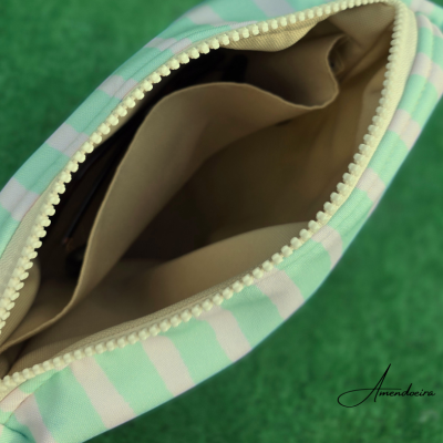 Mala às riscas verdes e brancas aberta a mostrar interior castanho