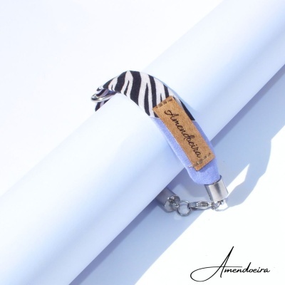 Pulseira têxtil padrão zebra com etiqueta Amendoeira e fecho metálico