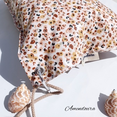 Almofada estampada de padrão animal print com conchas e corda em fundo branco