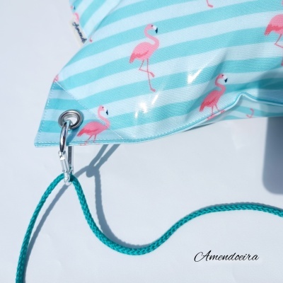 Bolsa azul clara com riscas brancas e flamingos cor de rosa, mosquetão e corda azul-turquesa