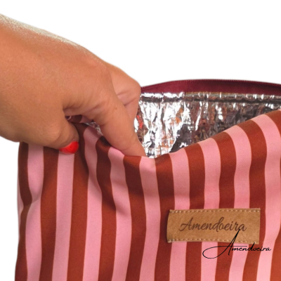 Bolsa térmica riscada rosa e castanho com etiqueta Amendoeira e forro prateado.