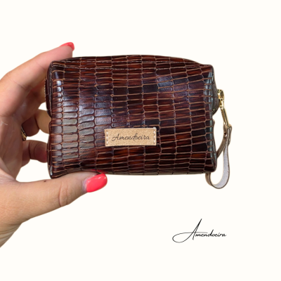 Bolsa pequena castanha com textura de pele de crocodilo e etiqueta Amoabeira