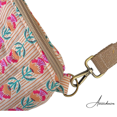 Mala tipo pochete com padrão floral bege e alça castanha com mosquetão