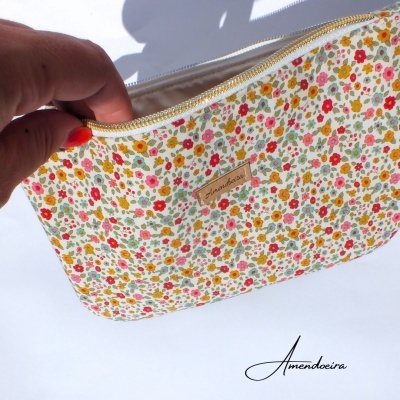 Necessaire floral colorida com fecho dourado e etiqueta Janaduda