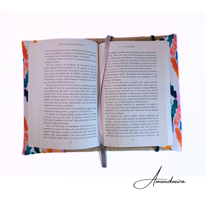 Livro aberto com capa colorida floral e marcador cinzento