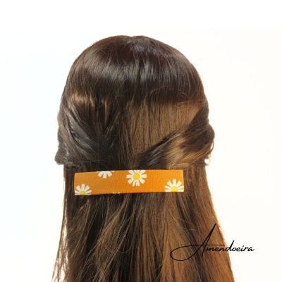 Presilha de cabelo laranja com flores brancas no cabelo castanho escuro