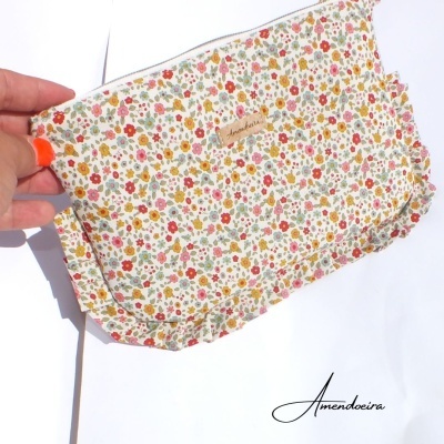 Estojo floral com etiqueta 'Amendoeira' e padrão colorido