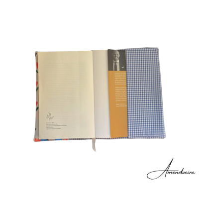 Livro aberto com capa azul aos quadrados e texto em português na lombada