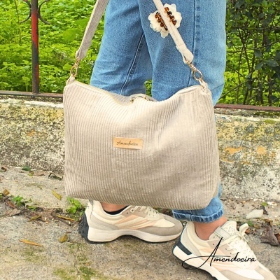 Sacola de tecido bege com etiqueta Amendoeira e ténis brancos