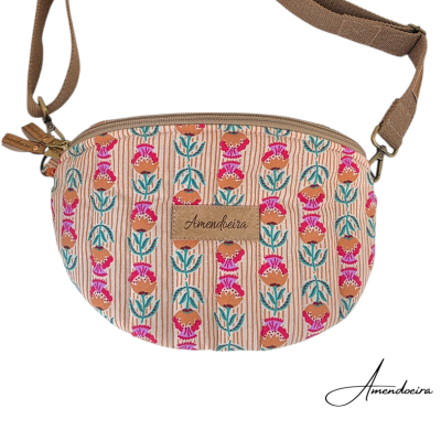 Bolsa tiracolo com padrão floral rosa, azul e castanho e etiqueta Amendoeira