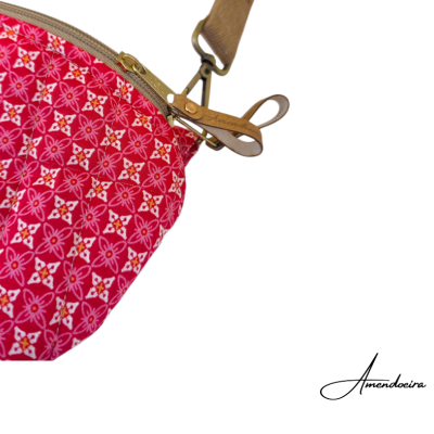 Mala de carteira vermelha com padrão floral rosa e branco e fecho metálico com puxador em couro