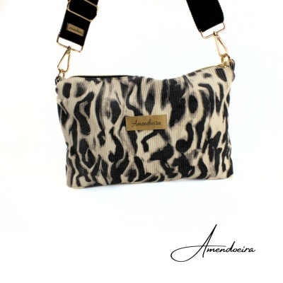 Bolsa animal print bege e preta com alça preta e etiqueta Anahira