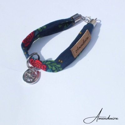 Pulseira azul com rosas vermelhas, fecho e pendente metálicos, etiqueta 'Amendoeira'