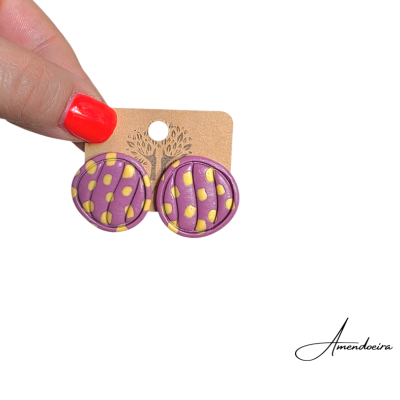 Brincos redondos roxo e amarelo com textura em relevo em cartão castanho claro