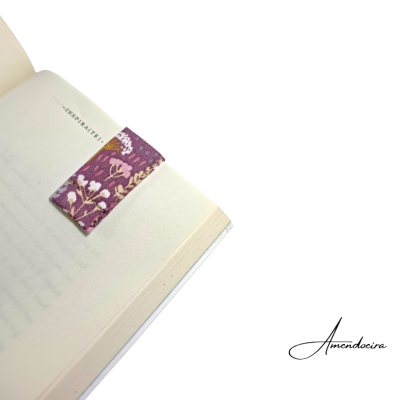 Marcador de páginas tecido floral roxo num livro aberto