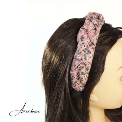 Faixa de cabelo rosa floral num manequim de cabelo castanho escuro