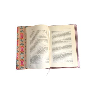 Livro aberto com capa protetora floral e interior xadrez