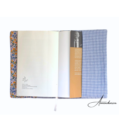 Capa de tecido azul com padrão vichy branco em livro aberto com interior floral e marcador