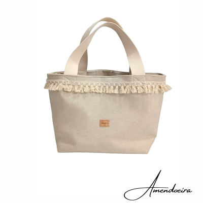 Bolsa de tecido bege claro com franjas e alças largas