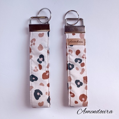 Dois porta-chaves de tecido floral com argolas metálicas e detalhes em couro castanho