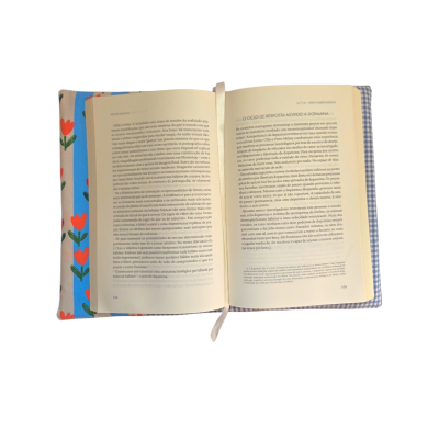 Livro aberto sobre capa de tecido florida e xadrez azul