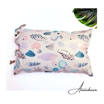 Almofada retangular com padrão de conchas coloridas em fundo claro