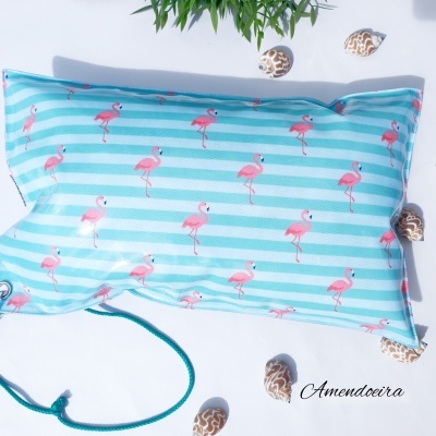 Capa de almofada azul com riscas brancas e flamingos cor-de-rosa, cordão e conchas ao redor
