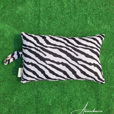 Almofada retangular padrão zebras preto e branco sobre relva verde