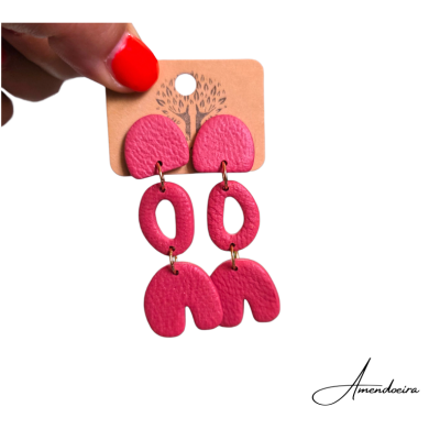 Brincos cor-de-rosa em couro apresentados num cartão castanho com desenho de árvore