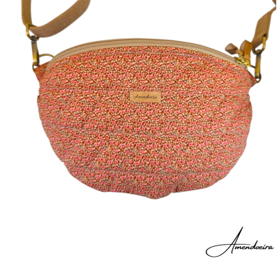 Bolsa de ombro floral vermelha e rosa com alça castanha e etiqueta Amendoeira.
