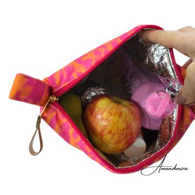 Bolsa térmica rosa e laranja com maçã, banana e garrafa rosa no interior