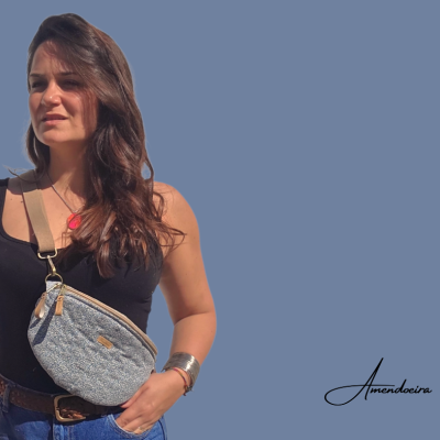 Mulher com mala tiracolo azul claro texturizada sobre fundo azul