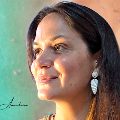 Brincos pendentes creme com textura marmoreada em mulher com cabelo castanho