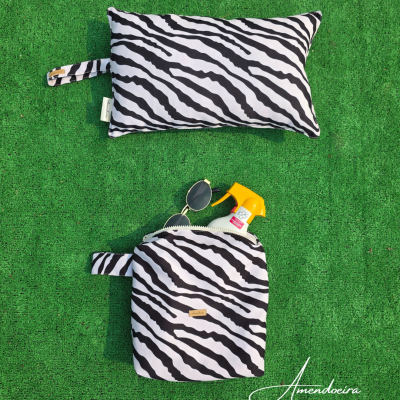 Almofada e saco com padrão zebra preto e branco sobre relva verde