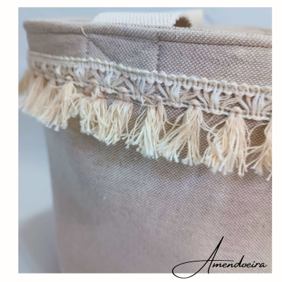 Cesto de tecido bege com franjas creme e texto Amendoeira