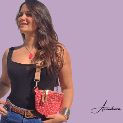 Bolsa rosa com padrão branco com alça bege em mulher com blusa preta