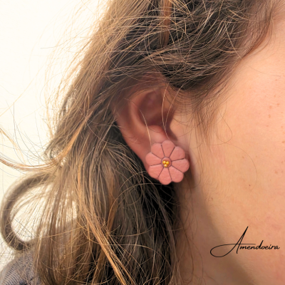 Brinco rosa em forma de flor com detalhes dourados no centro