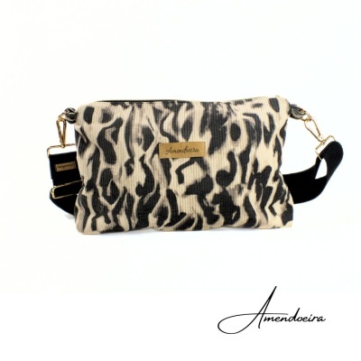Bolsa tiracolo com padrão de pele de animal preto e bege e etiqueta Amendoeira