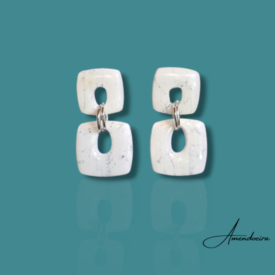 Brincos brancos com veios cinza em fundo azul-turquesa