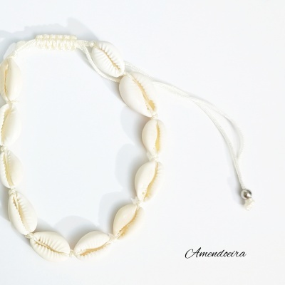 Pulseira de conchas brancas com fio ajustável sobre fundo branco e texto Amendoira