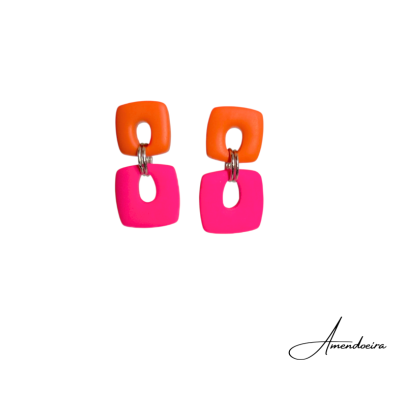 Brincos quadrados laranja e rosa unidos por argolas metálicas.