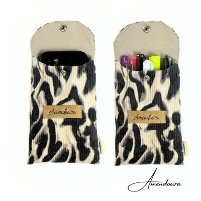 Bolsas de tecido com padrão zebra preto e branco, fecho de botão e etiqueta Amendoeira.