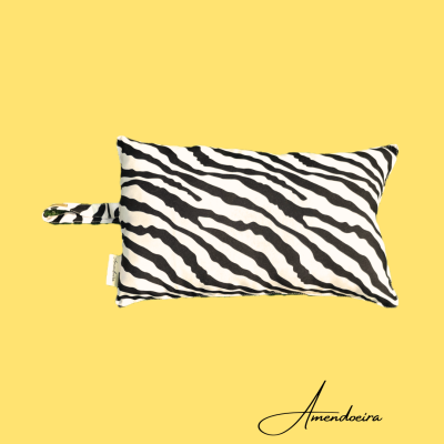 Almofada com padrão zebra preto e branco sobre fundo amarelo com texto Amendoeira