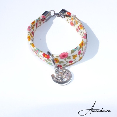 Pulseira têxtil floral com pendente de sol e lua
