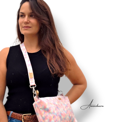 Mulher com mala de ombro colorida com padrão abstrato em fundo branco