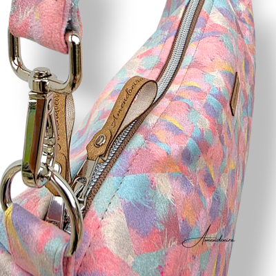 Mala de mão colorida com padrão pastel e fecho metálico com etiqueta de pele 'Amendoeira'