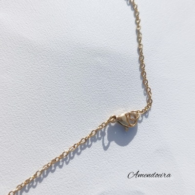 Colar dourado com fecho de lagosta sobre fundo branco