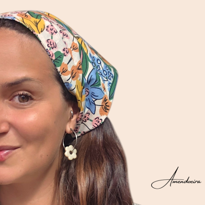Lenço floral colorido na cabeça de mulher com brincos de flor branca