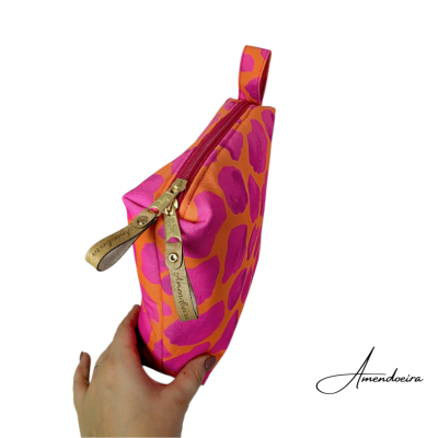 Estojo colorido com padrão de animal print laranja e rosa, com fecho de correr e puxadores dourados